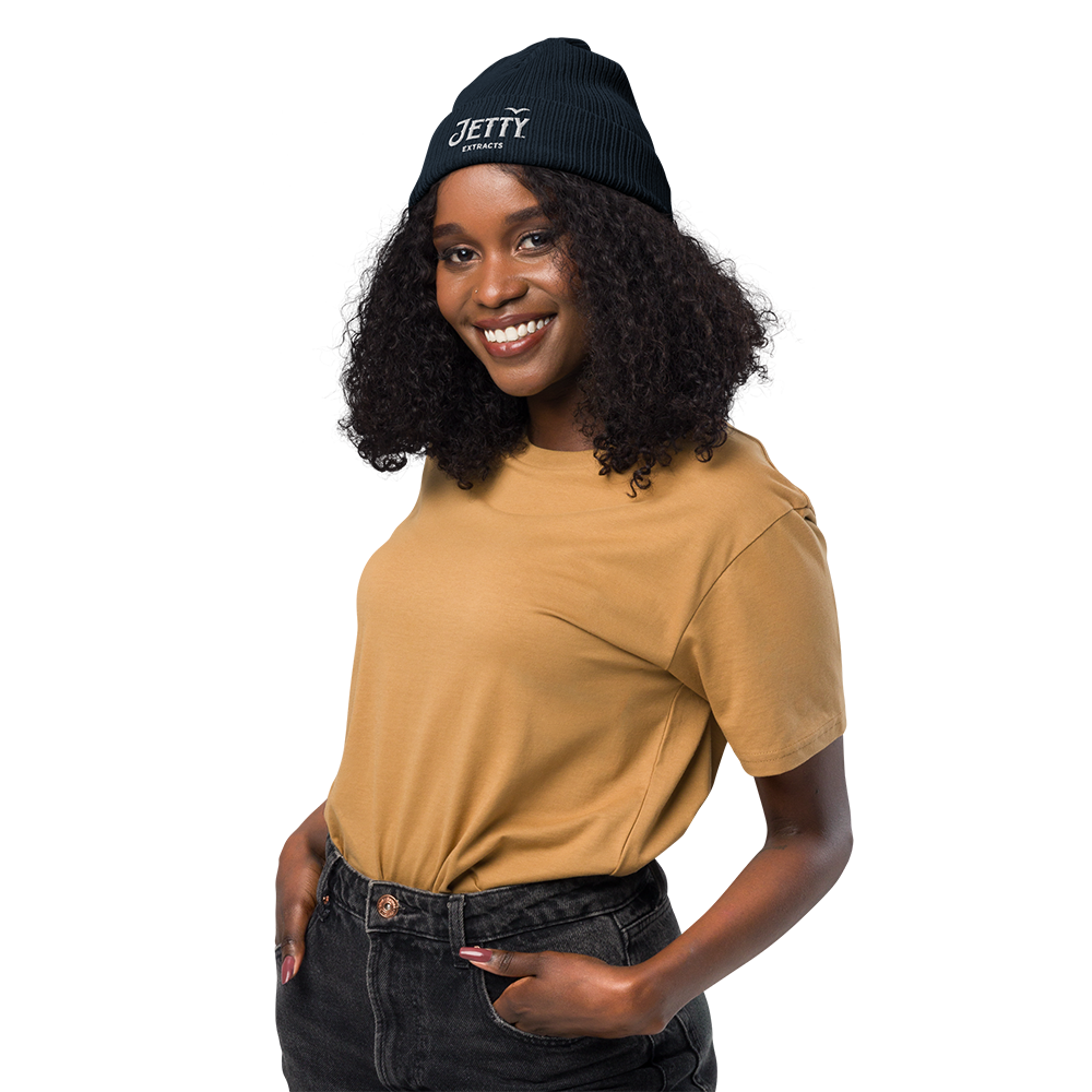 Woman wearing a Jetty Extracts beanie with white embroidered logo outdoors
