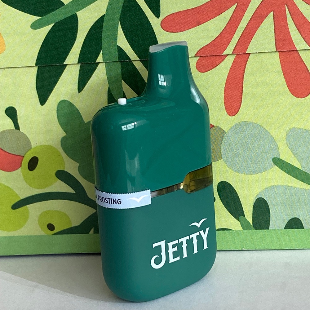A teal green jetty all-in-one vape is shown with its strain name label horizontally on the side.