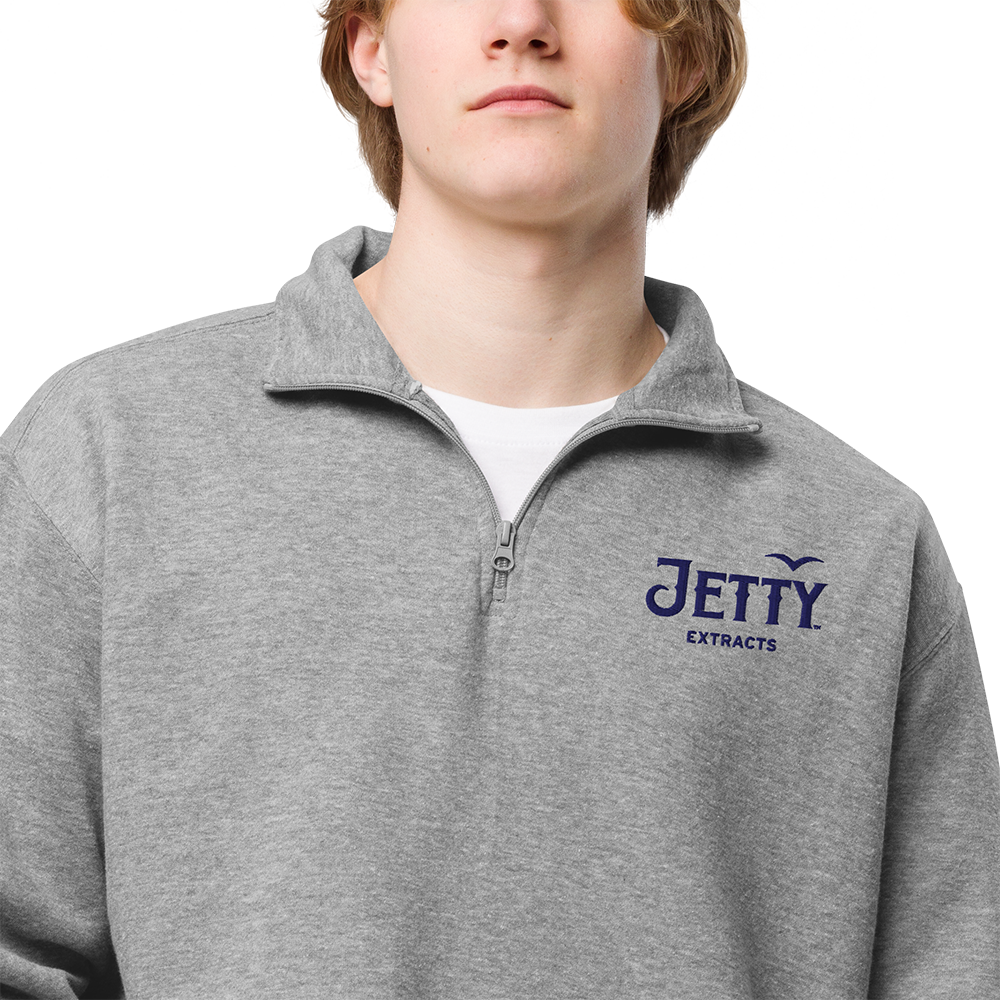 Carbon gray Jetty Extracts fleece pullover with navy embroidered logo and white Jetty bird on right sleeve.