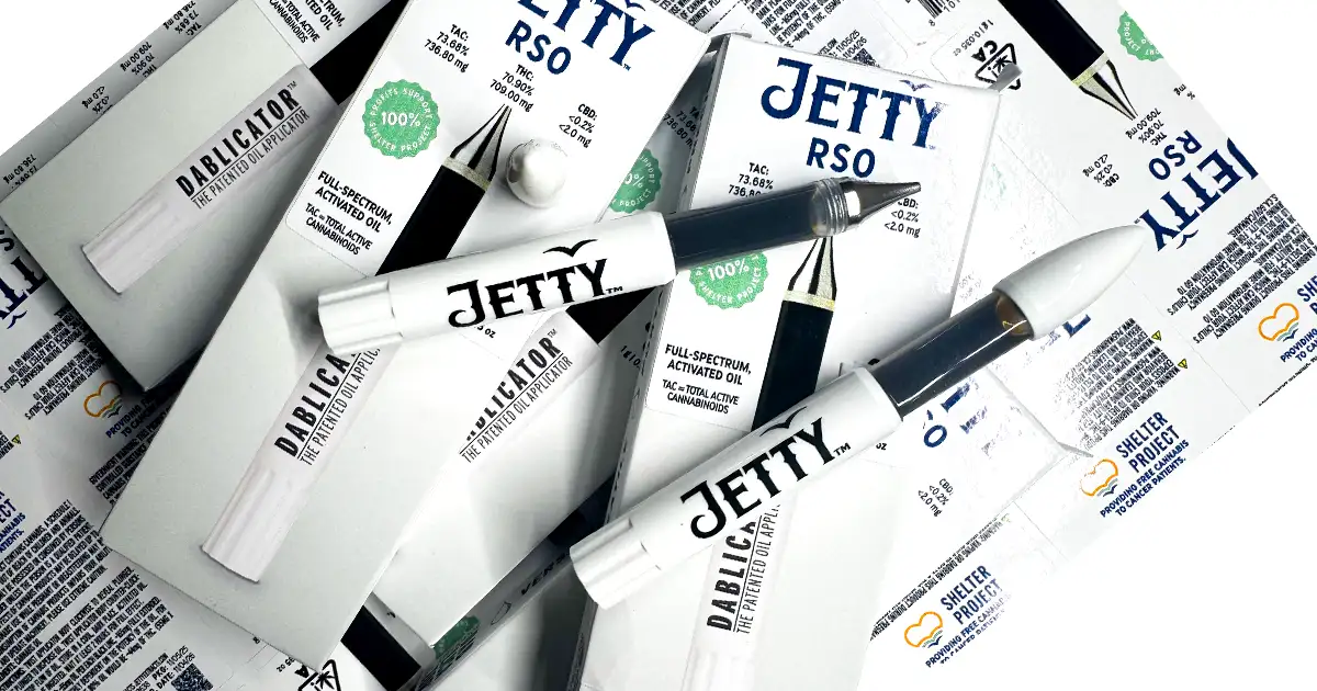 Overhead view of multiple Jetty Extracts RSO dablicators and packaging arranged together, highlighting full-spectrum activated oil and Shelter Project support for cancer patients.