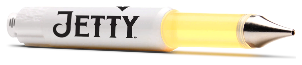 Close-up angled view of a Jetty Extracts Dablicator cannabis oil applicator highlighting the white barrel with logo, transparent chamber filled with golden oil, and precision metal dispensing tip