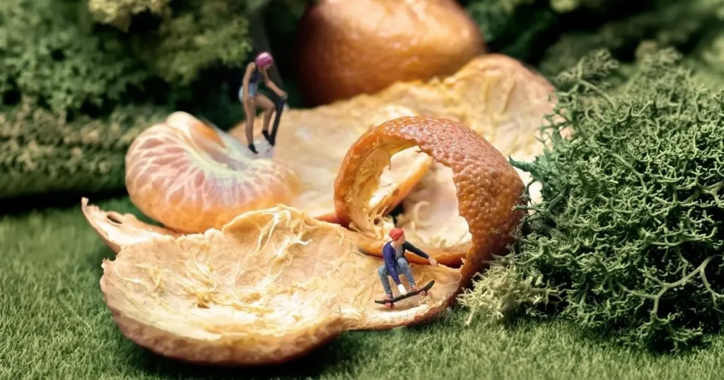 Jetty live resin citris flavor shown by miniature figures skateboarding on an orange peel curled up like a ramp.